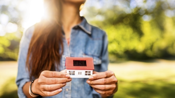 woman holding mini house